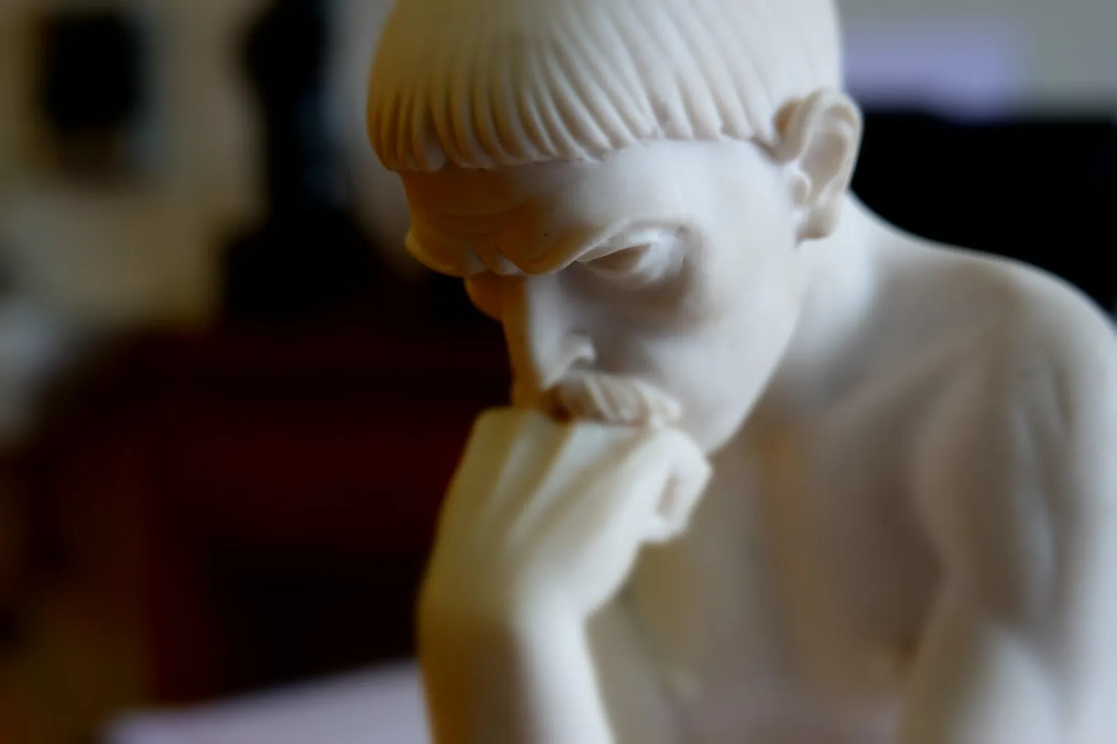 Steinskulptur eines nachdenklichen Menschen in der Praxis