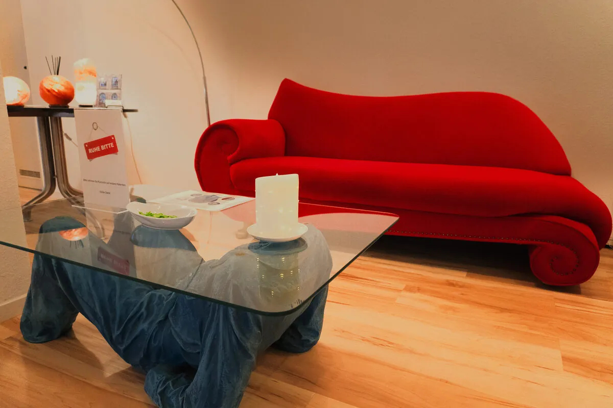 Wartebereich der Praxis mit rotem Sofa
